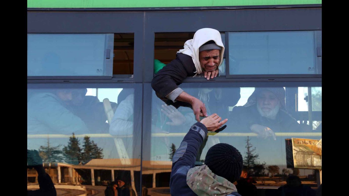 Civilians arrive in the opposition-controlled Khan al-Aassal region, to the west of Aleppo, on Thursday, December 15. Most of the civilians from Aleppo will be taken to a rebel-controlled area in the neighboring province of Idlib.