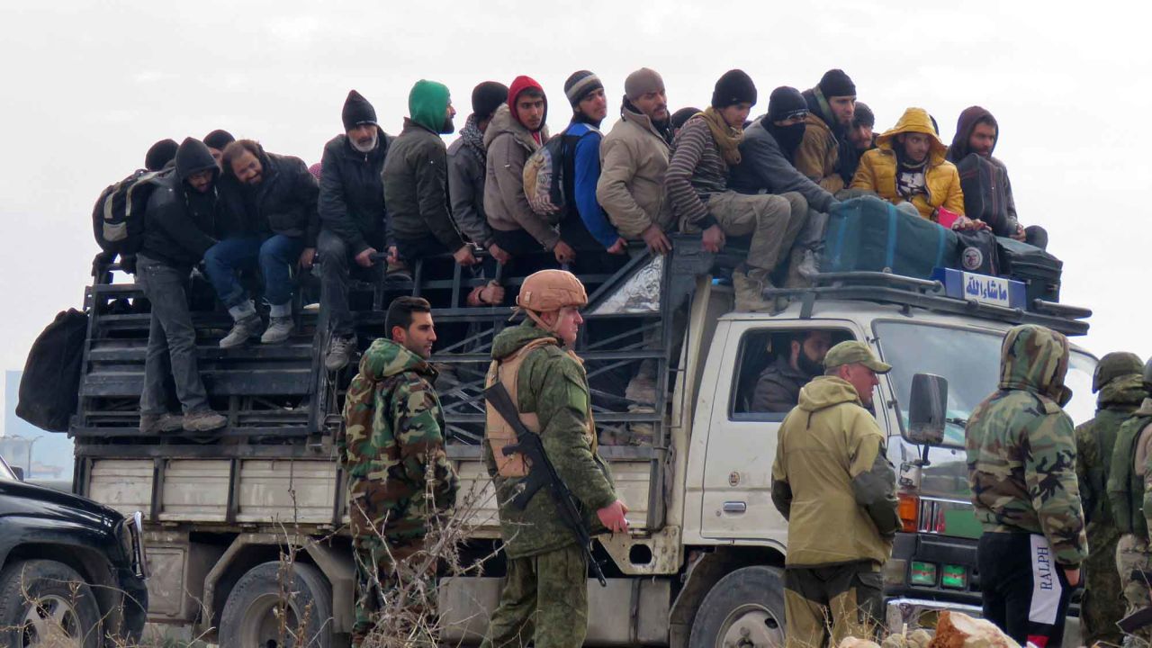 Russian soldiers and Syrian pro-government forces look on as civilians and rebel fighters are evacuated from Aleppo on Friday, December 16. Evacuations began a day earlier under a new ceasefire between rebels and pro-government forces.