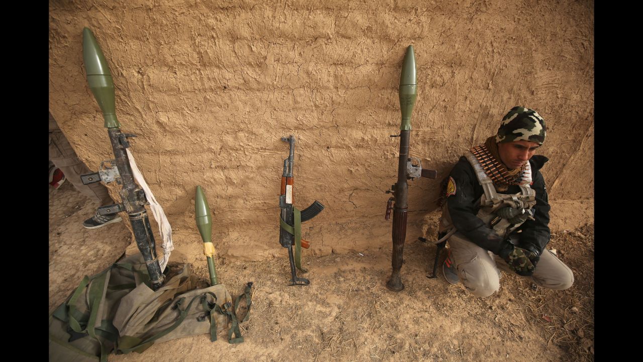 A Shiite fighter sits beside weapons as his units enter the village of Shwah, south of the city of Tal Afar, in December 2016 during an ongoing operation against ISIS jihadists.