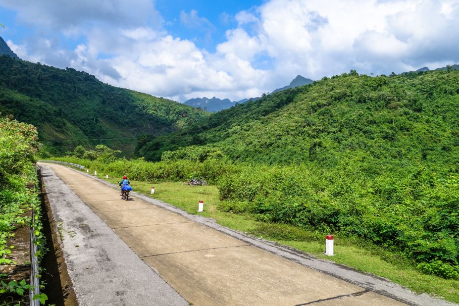 The author rides through jungled terrain along the Western Ho Chi Minh Highway.