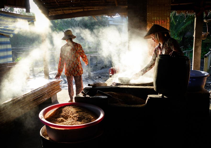 Vendors clean and prepare grain to be sold at the floating markets in the Mekong Delta. 