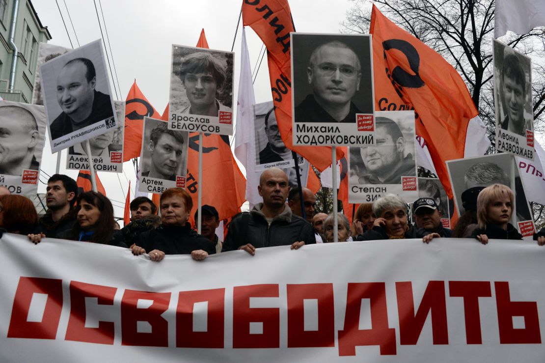 Thousands of Russians carry placards of political prisoners including Khodorkovsky and a banner reading "Freedom!" during an opposition rally in Moscow in 2013. 