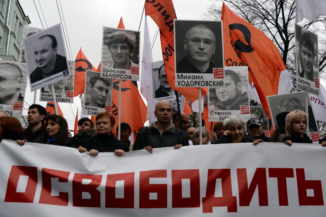 Thousands of Russians carry placards of political prisoners including Khodorkovsky and a banner reading "Freedom!" during an opposition rally in Moscow in 2013.
