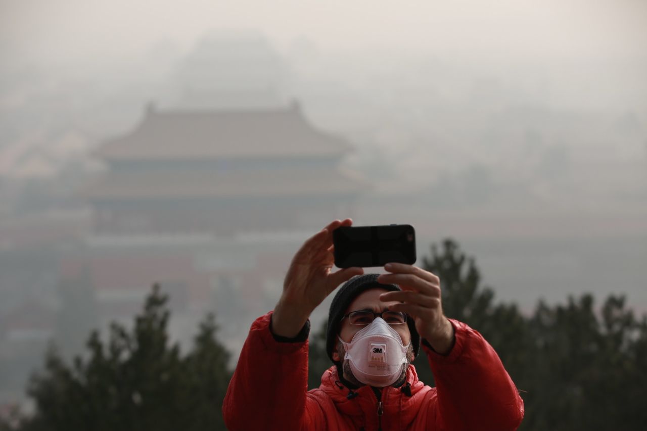 A tourist takes a selfie in Beijing on Saturday, December 17.