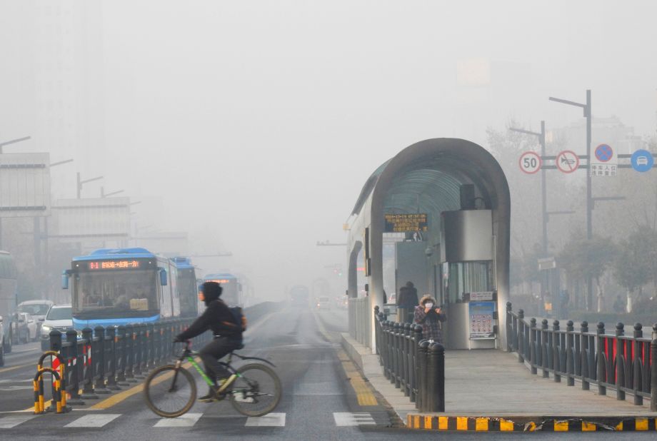 A cyclist crosses a smog-shrouded street in Lianyungang on December 19.