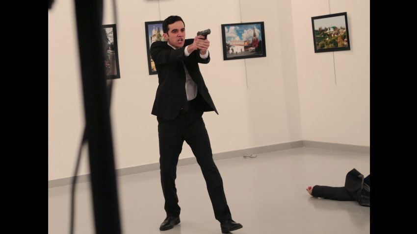 An unnamed gunman gestures after shooting the Russian Ambassador to Turkey, Andrei Karlov, at a photo gallery in Ankara, Turkey, Monday, Dec. 19, 2016. The Russian foreign ministry spokeswoman said he was hospitalized with a gunshot wound. (AP Photo/Burhan Ozbilici)