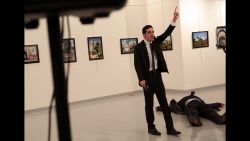 A man gestures near to the body of a man at a photo gallery in Ankara, Turkey, Monday, Dec. 19, 2016. An Associated Press photographer says a gunman has fired shots at the Russian ambassador to Turkey. The ambassador's condition wasn't immediately known. (AP Photo/Burhan Ozbilici)