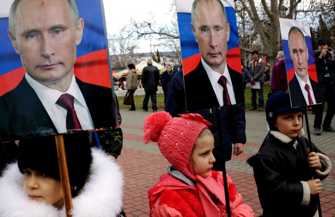 Children hold portraits of Putin during a rally to mark a Russian holiday -- Defender of the Fatherland day -- in the Crimean city of Sevastopol, on February 23, 2016.