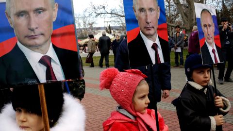 Children hold portraits of Putin during a rally to mark a Russian holiday -- Defender of the Fatherland day -- in the Crimean city of Sevastopol, on February 23, 2016.