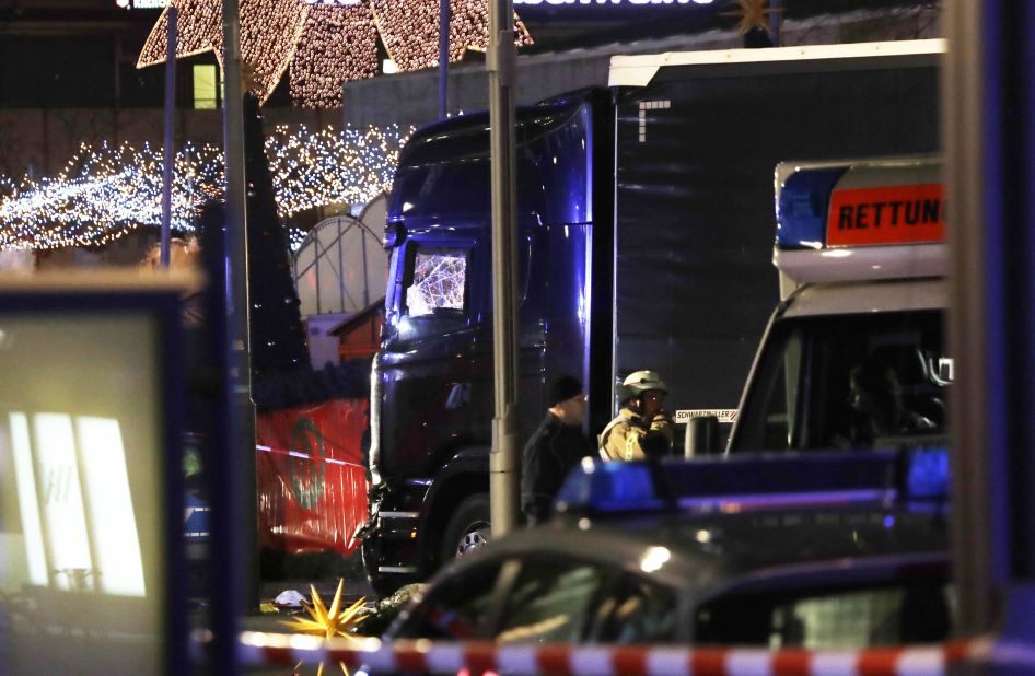 Police stand beside the damaged truck that crashed into the market.