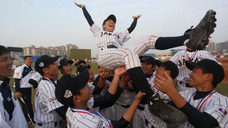 Japanese players hold up Hosiko Temma after defeating Korea to win an under-12 baseball tournament in Zhongshan, China, on Tuesday, December 13.