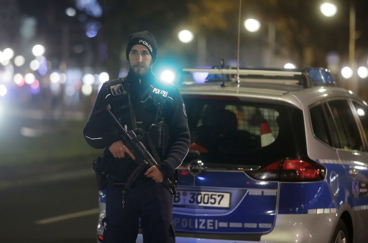 An armed police officer stands near the scene.