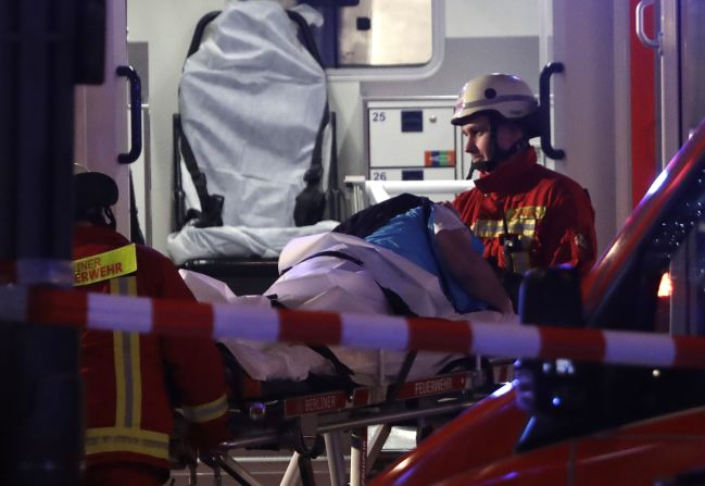 First responders load an injured person into an ambulance.