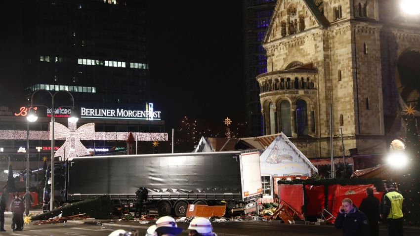 Policemen stand next to a truck that crashed into a Christmas market in Berlin, on December 19, 2016 killing at least one person and injuring at least 50 people.
Ambulances and police rushed to the scene after the driver drove up the pavement of the market in a central square popular with tourists less than a week before Christmas, in a scene reminiscent of the deadly truck attack in Nice.