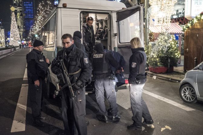 Police take someone into custody near the market.