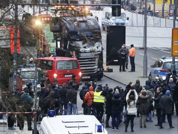 Members of the press crowd around the crash site on December 20.