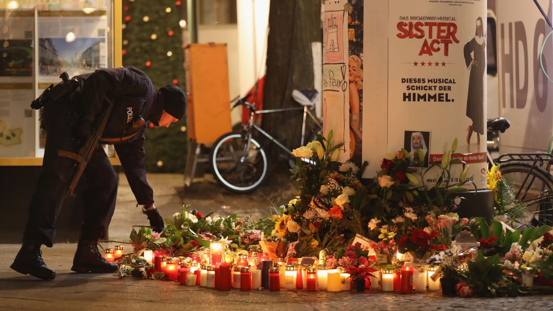 A police officer places a candle at a makeshift memorial in Berlin on December 20.