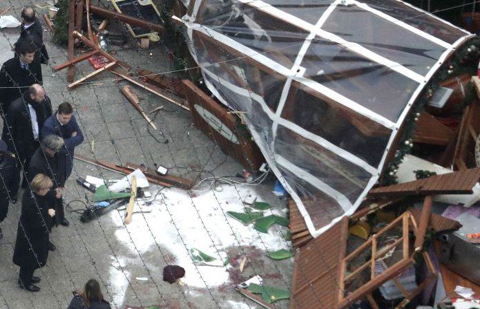 Merkel, bottom left, views the scene of the attack.