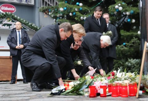 German Chancellor Angela Merkel lays flowers at the memorial on December 20. She is joined by, from left, Berlin Mayor Michael Muller, Minister of the Interior Thomas de Maiziere and Foreign Minister Frank-Walter Steinmeier.