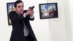 An unnamed gunman gestures after shooting the Russian Ambassador to Turkey, Andrei Karlov, at a photo gallery in Ankara, Turkey, Monday, Dec. 19, 2016. The Russian foreign ministry spokeswoman said he was hospitalized with a gunshot wound. (AP Photo/Burhan Ozbilici)