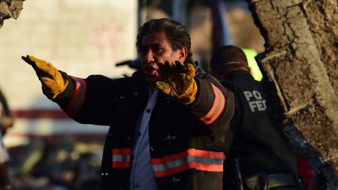A fireman gestures to his colleagues as they work at the scene of the explosion.