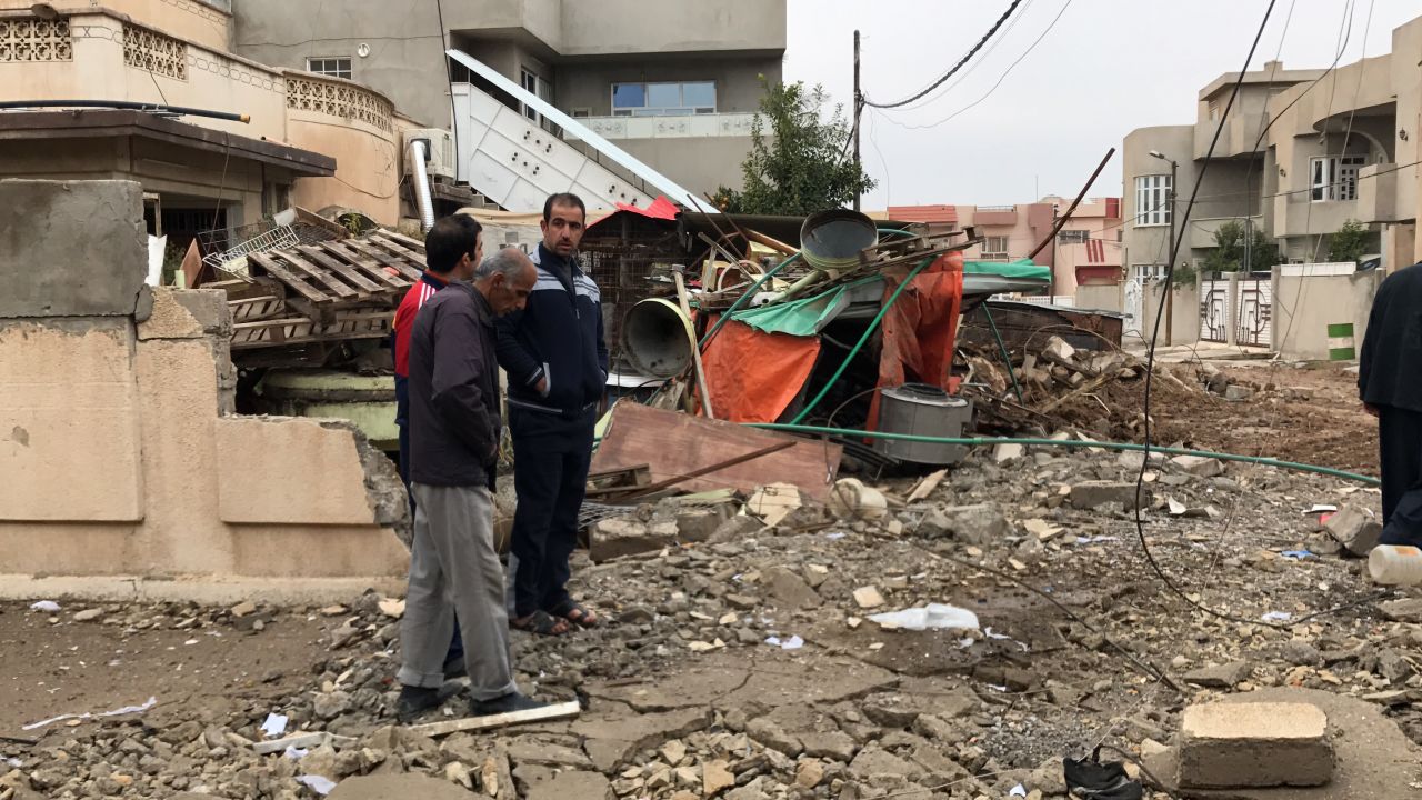 Residents outside a house in eastern Mosul that was damaged during the battles against ISIS.