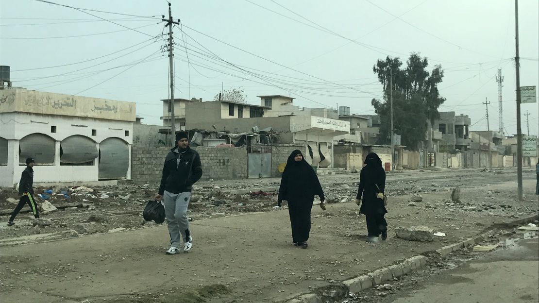Residents walk in al-Samah neighborhood in liberated areas in eastern Mosul. Many women were seen uncovering their faces, one of many things they could not do under the control of ISIS.