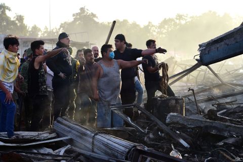 Rescuers and local volunteers search the debris for victims.
