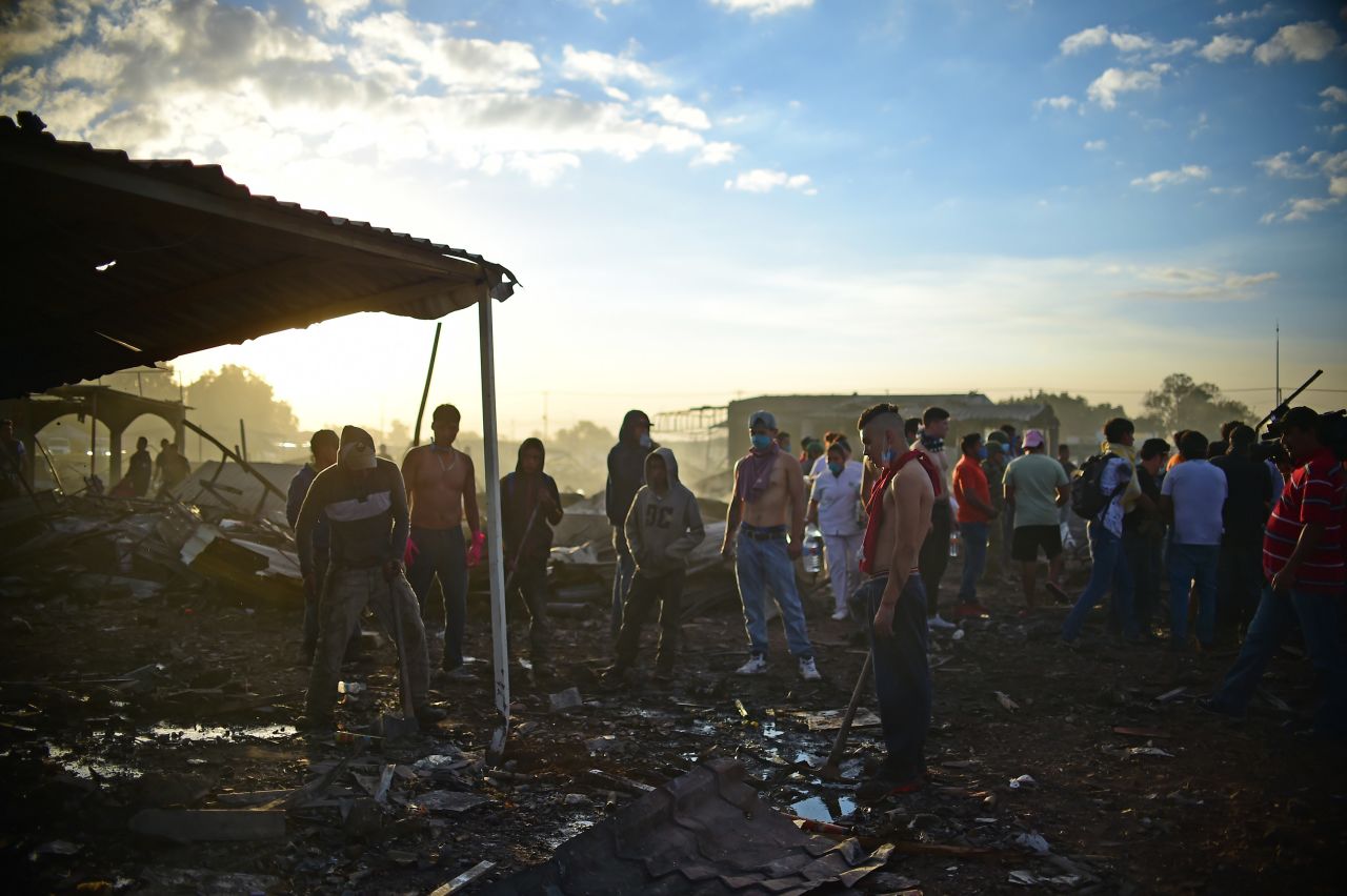 Rescuers and survivors gather amid the destroyed market.