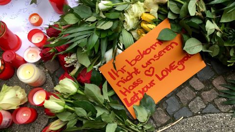 People leave tributes to the Berlin victims. One note reads, "Let your love grow."
