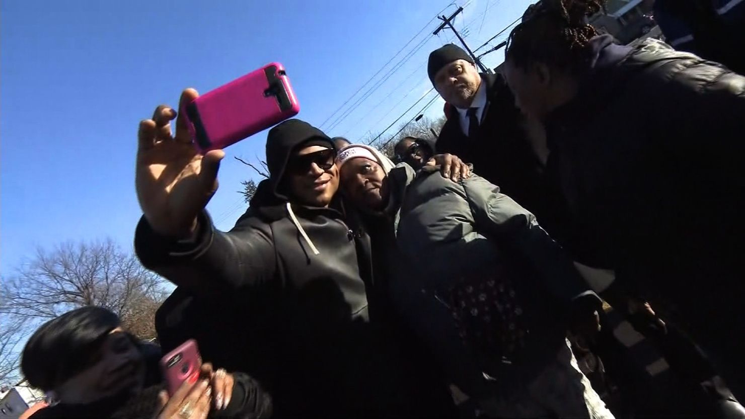 LL Cool J takes selfies with residents in the neighborhood where he grew up.