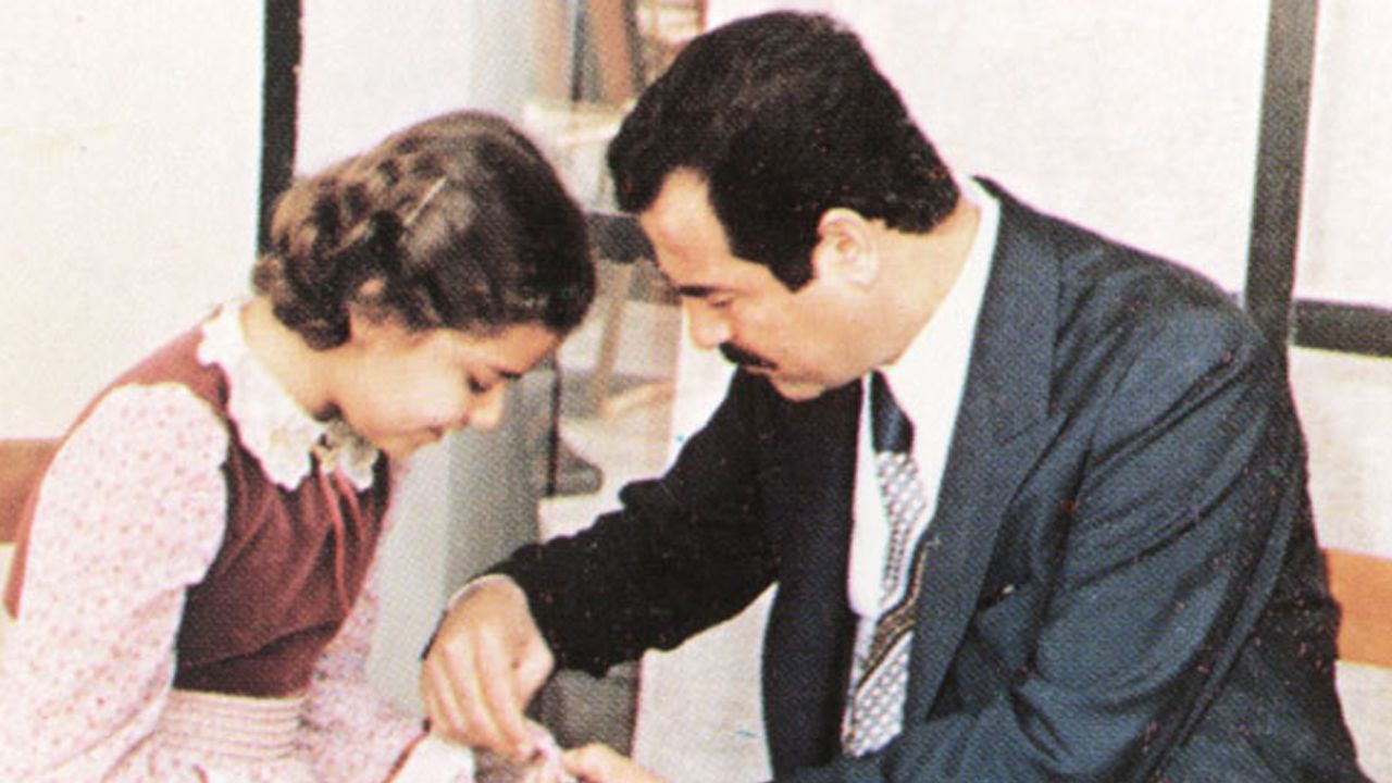An undated photo of Saddam Hussein helping his daughter, Raghad, during a visit with family friends near Baghdad, Iraq.