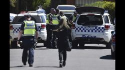 Police accompany a woman as they attend the scene where a house was raided at Meadow Heights in Melbourne, Australia, Friday, Dec. 23, 2016. Police in Australia detained five suspects who were allegedly planning a series of Christmas Day bomb attacks in the heart of the country's second largest city, officials said Friday. (Julian Smith/AAP Image via AP)
