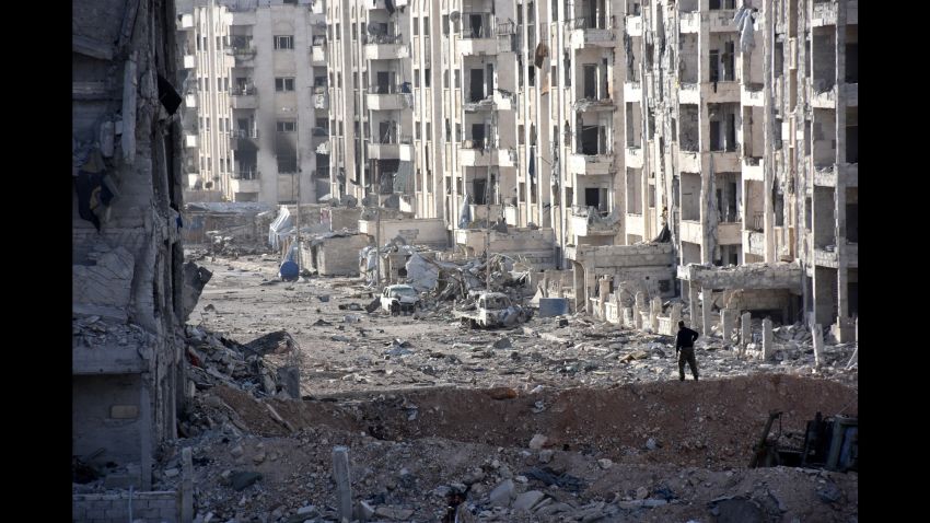 TOPSHOT - A member of the Syrian pro-government forces stands amid heavily damaged buildings in Aleppo's 1070 district on November 8, 2016, after troops seized it from rebel fighters.Syrian state media said government forces had advanced southwest of divided second city Aleppo, seizing the 1070 district from rebel forces. The Syrian Observatory for Human Rights monitor also reported the advance, saying it would allow government forces to protect areas already under their control on the southern outskirts of Aleppo. / AFP / GEORGES OURFALIAN        (Photo credit should read GEORGES OURFALIAN/AFP/Getty Images)