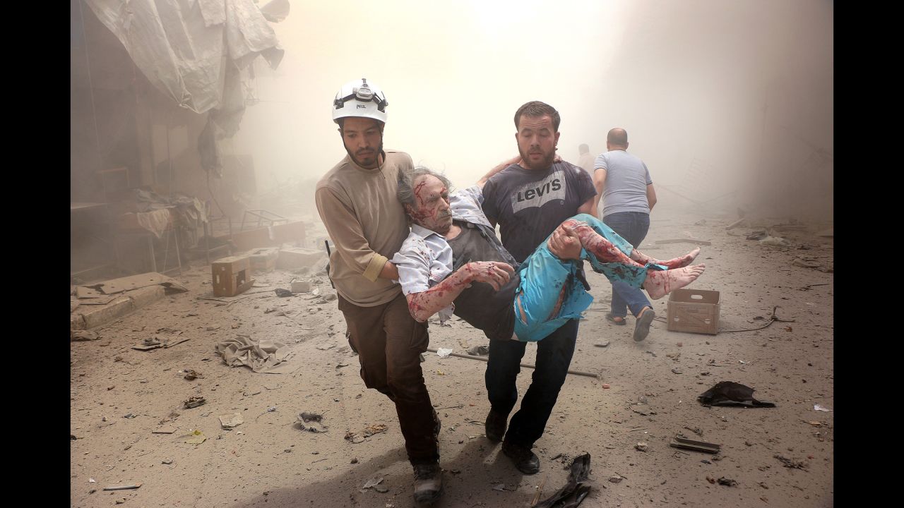 Search and rescue team members carry an injured man after Syrian regime airstrikes targeted the Meshed neighborhood of Aleppo on July 21, 2016.