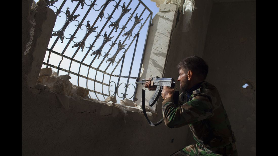 A rebel fighter aims his weapon toward Syrian government forces' positions at the Menagh military airport near Aleppo on March 13, 2013.
