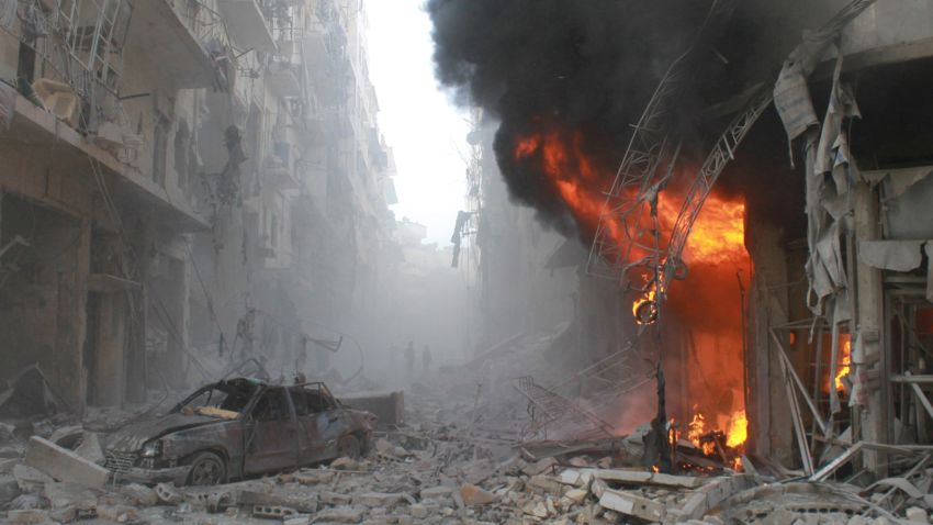 Debris cover a street and flames rise from a building following a reported air strike by Syrian government forces on March 7, 2014 during the Friday prayer in the Sukkari neighborhood of the northern city of Aleppo. More than 140,000 people have been killed in Syria since the start of a March 2011 uprising against the Assad family's 40-year rule. AFP PHOTO / BARAA AL-HALABI        (Photo credit should read BARAA AL-HALABI/AFP/Getty Images)