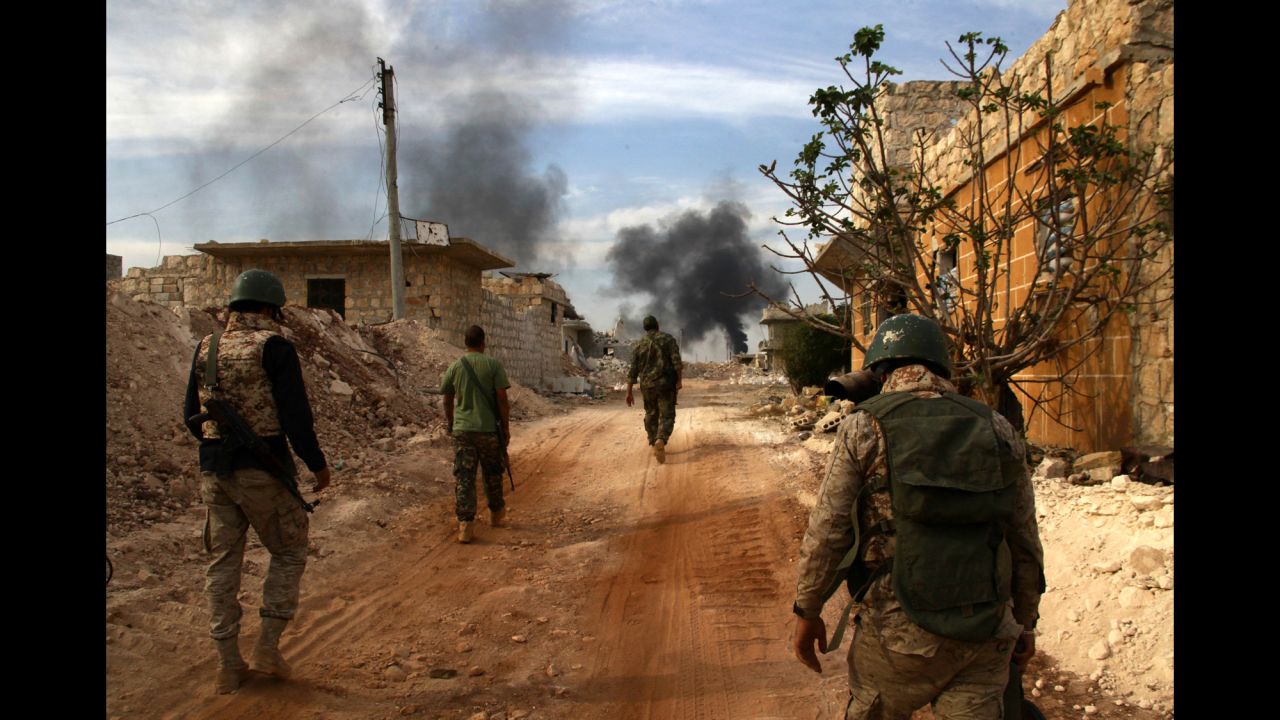 Syrian government forces walk in the strategic area of the Bazo hilltop, on the southern outskirts of Aleppo, as they advance to seize the rebel-held eastern part of the city on October 25, 2016.