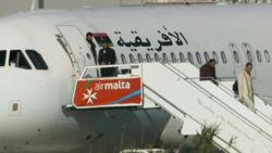 An Afriqiyah Airways plane stands on the tarmac at Malta's Luqa International airport as passengers depart, Friday, Dec. 23, 2016. Hijackers diverted the Libyan commercial plane to Malta on Friday and threatened to blow it up with hand grenades, Maltese authorities and state media said. (AP Photo)
