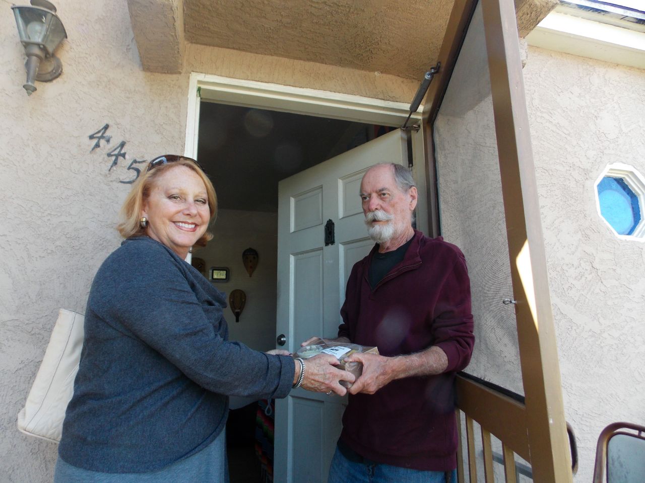 Debbie Case, CEO of the Meals on Wheels San Diego County, delivers lunch and dinner to 75-year-old David Kelly. Kelly lost his sight about two years ago and reluctantly gave up cooking. 