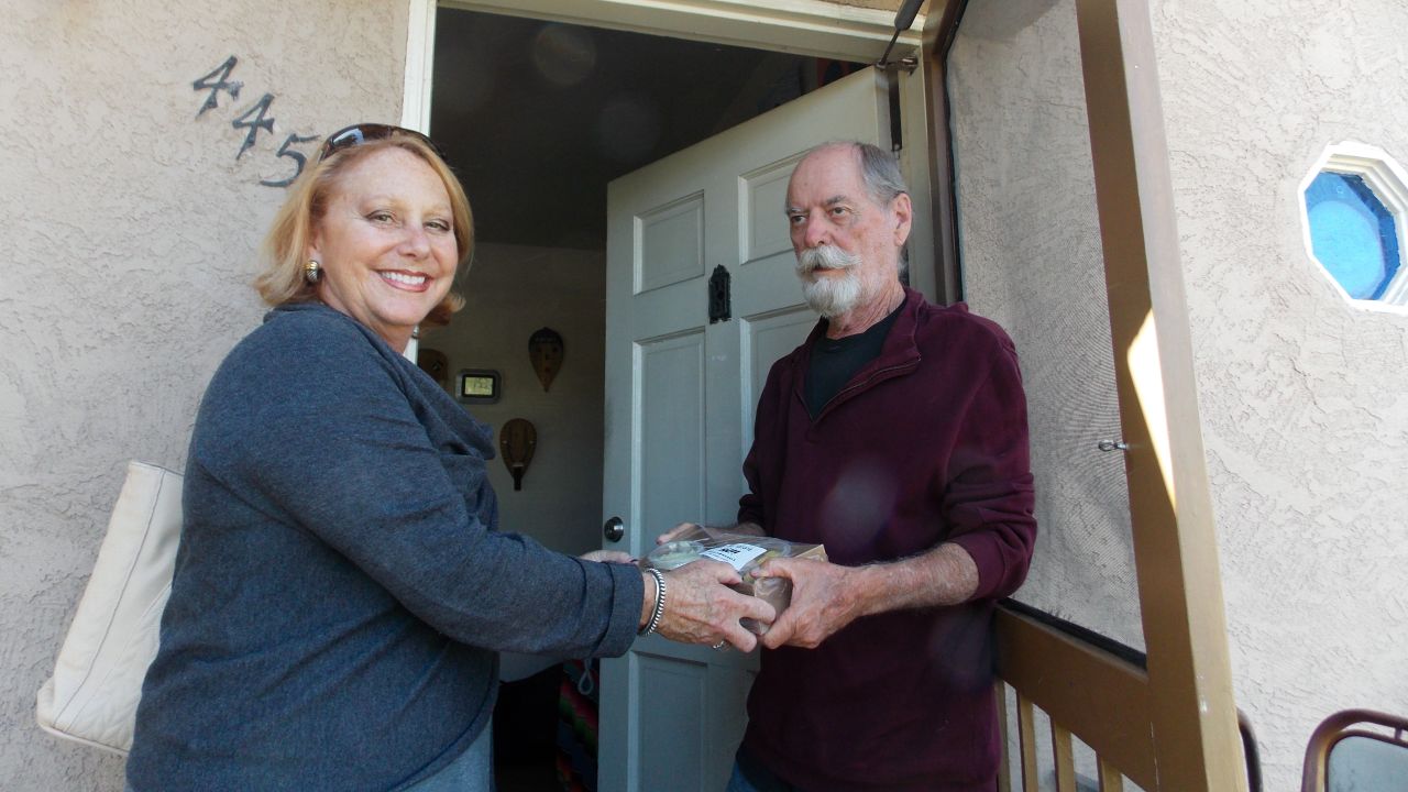 Debbie Case, CEO of the Meals on Wheels San Diego County, delivers lunch and dinner to 75-year-old David Kelly. Kelly lost his sight about two years ago and reluctantly gave up cooking. (Anna Gorman/KHN)