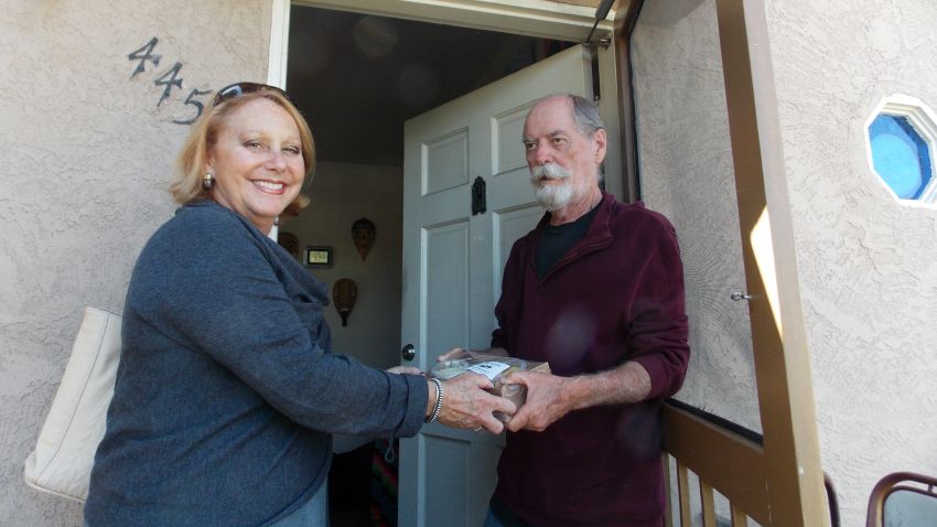 Debbie Case, CEO of the Meals on Wheels San Diego County, delivers lunch and dinner to 75-year-old David Kelly. Kelly lost his sight about two years ago and reluctantly gave up cooking. (Anna Gorman/KHN)