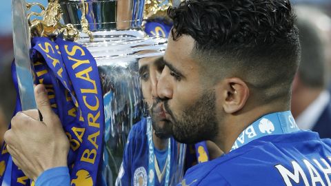 Leicester City's Algerian midfielder Riyad Mahrez kisses the English Premier League trophy.