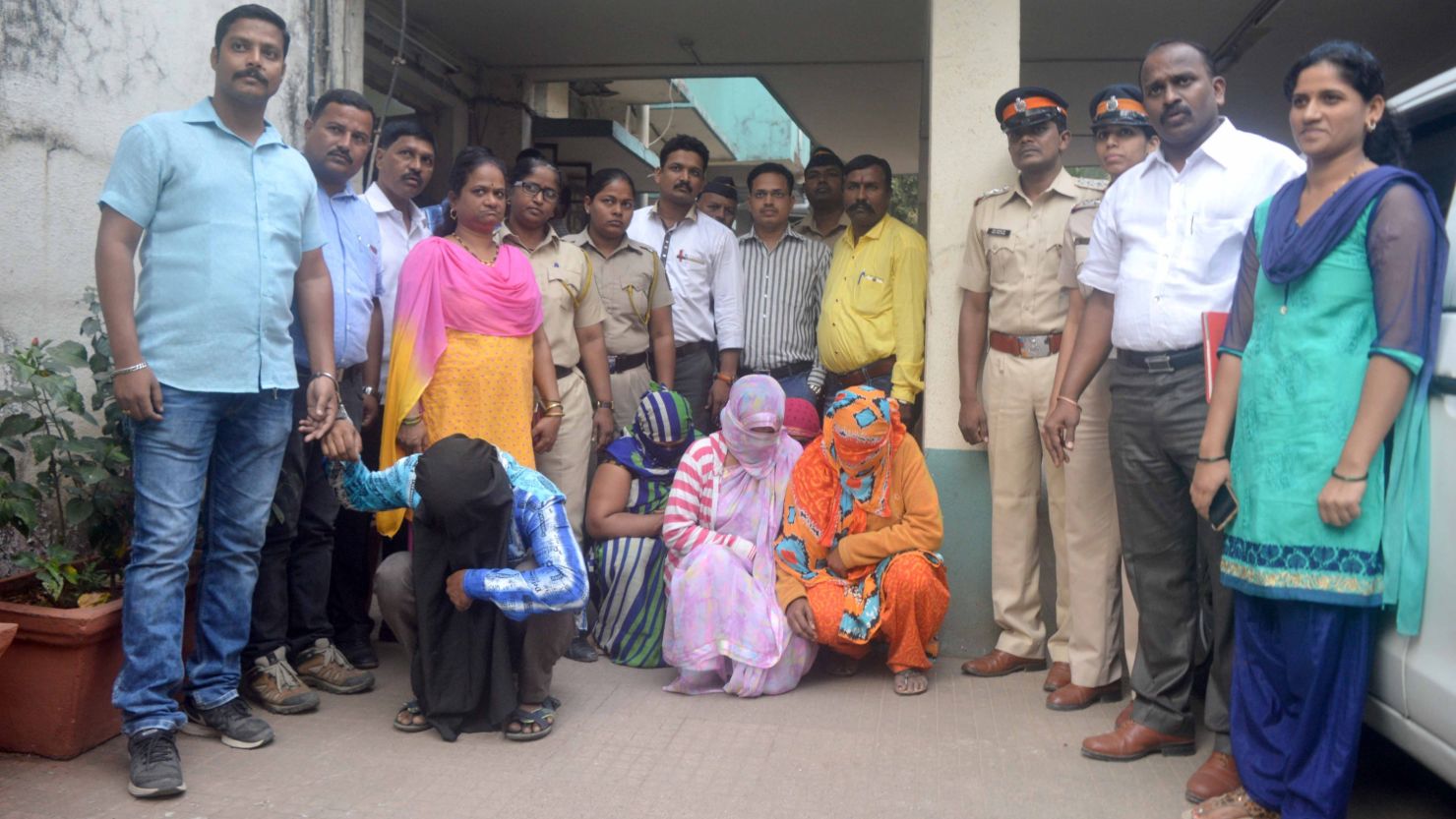 Police stand with the members of an alleged child trafficking gang in Mumbai.