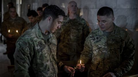 U.S. Army personnel light candles during Christmas Eve Mass in the Assyrian Orthodox church of Mart Shmoni, in Bartella, Iraq.