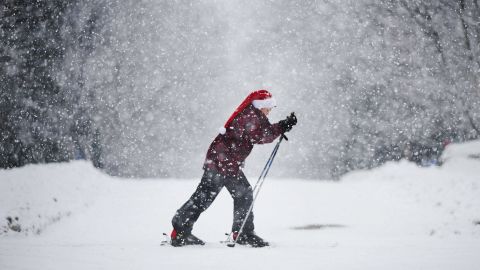 A boy wearing a Santa hat skis along a street near Montreal, Canada on December 24.
