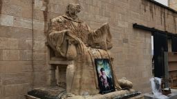 A religious statue vandalized by ISIS stands outside Mart Shmoni Church in Bartella, Iraq.