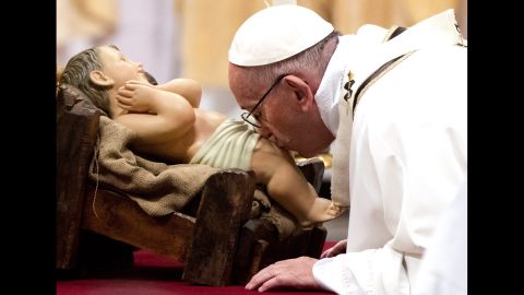 Pope Francis kisses a figure of baby Jesus during a Midnight Mass of Christmas in Saint Peter's Basilica at the Vatican, on December 25.