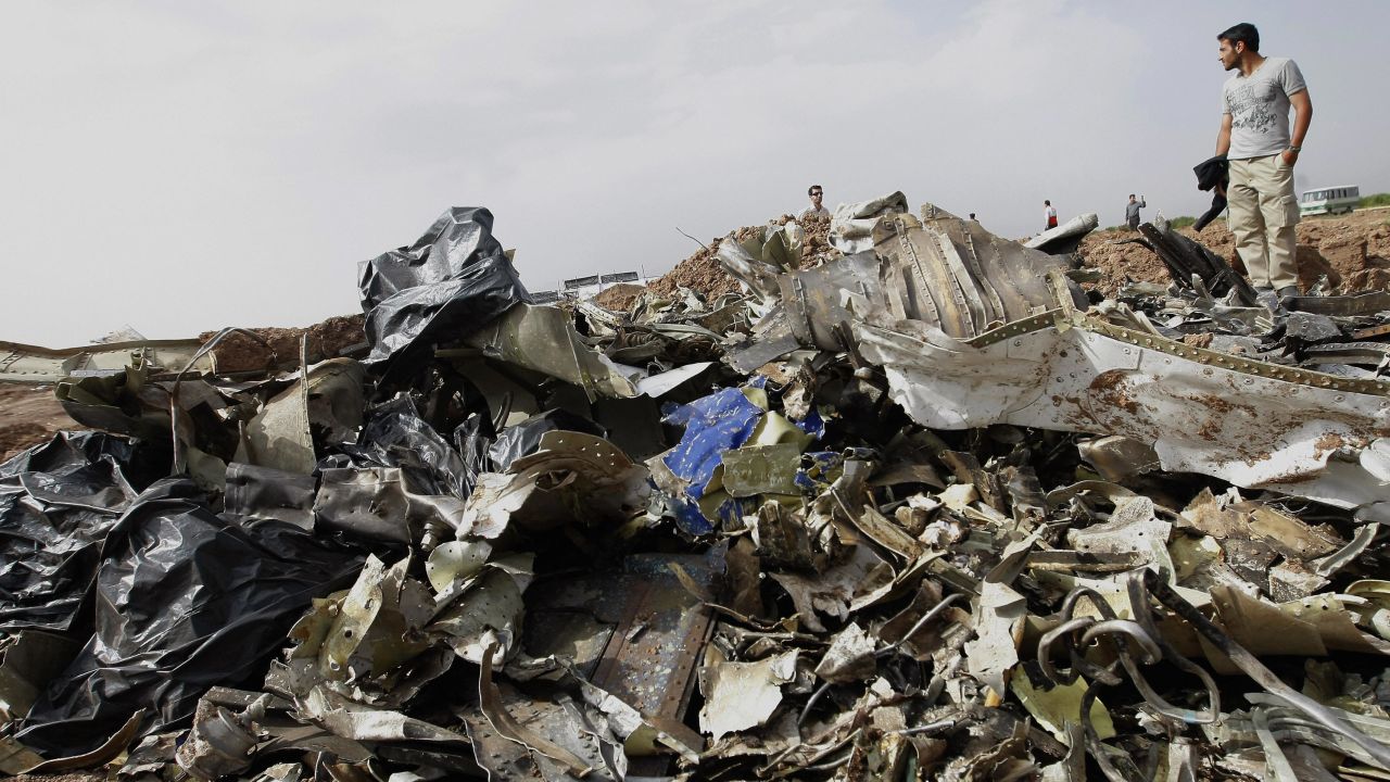 An Iranian man stands next to debris of the Caspian Airlines Tupolev-154 at its crash site near the city of Qazvin, northwest of Tehran, on July 16, 2009. 