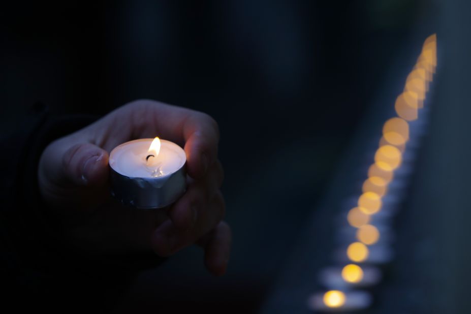 A man places a candle outside the building of the famed Alexandrov Ensemble, the Russian army's official dance and choir company, in Moscow.